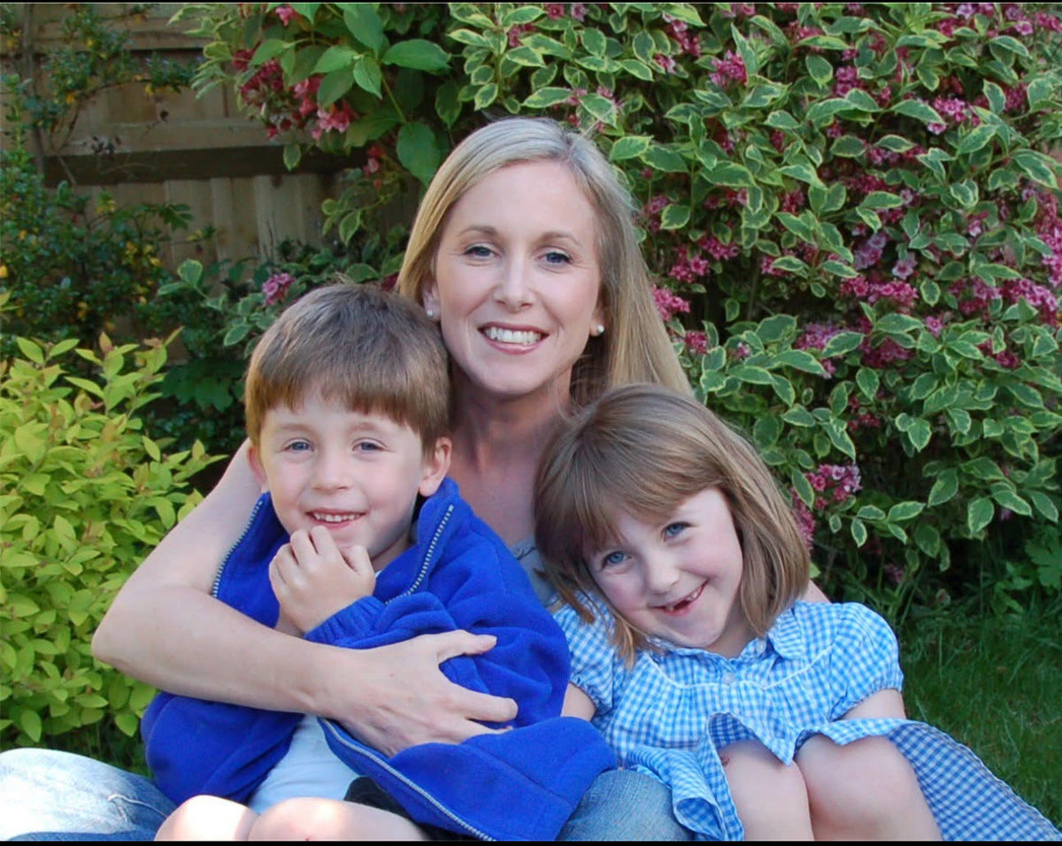 Karen sitting in the garden with her young children, Will and Alexandra.
