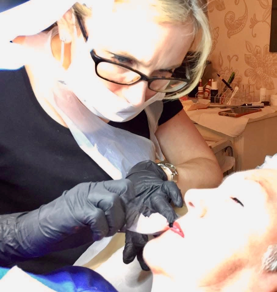 Karen wearing a mask and gloves while carrying out a permanent lip colour treatment.