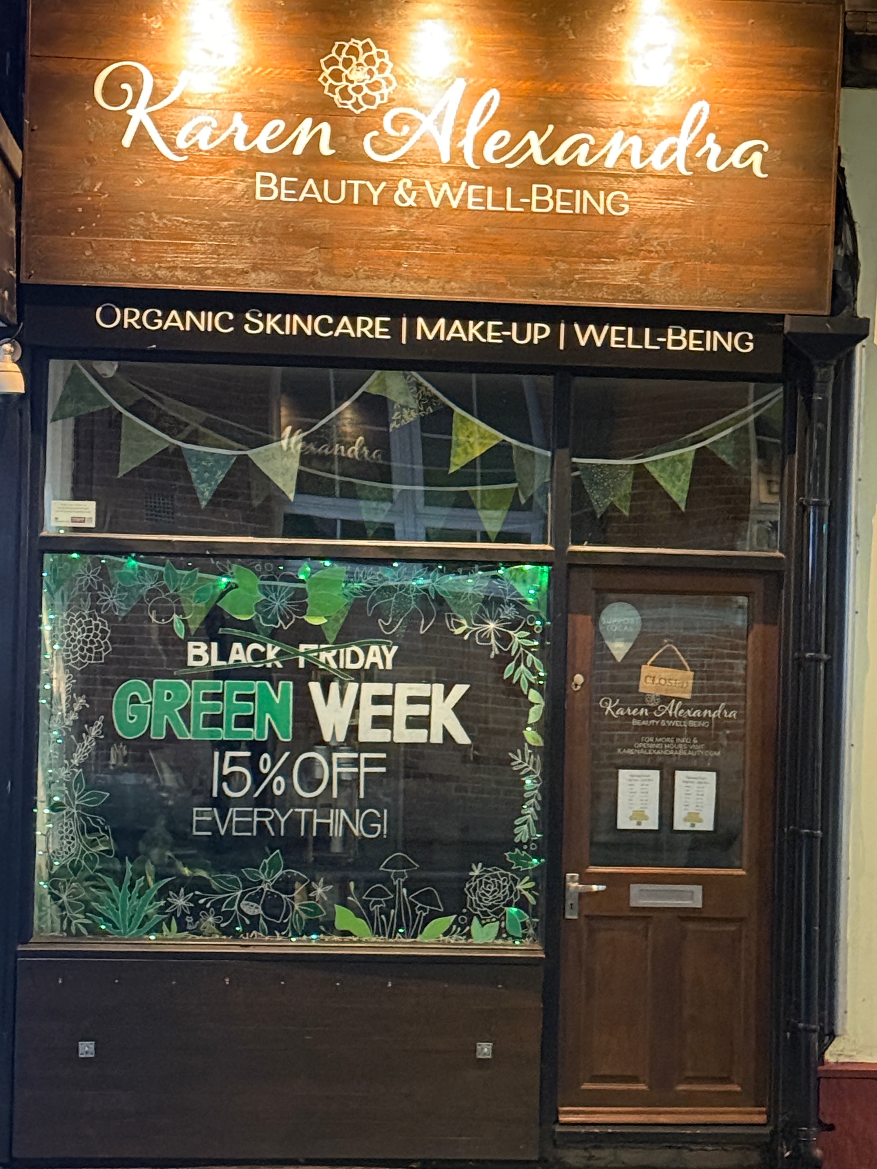 Storefront with a sign for Karen Alexandra Beauty & Well-Being and a promotional sign for a Black Friday sale.