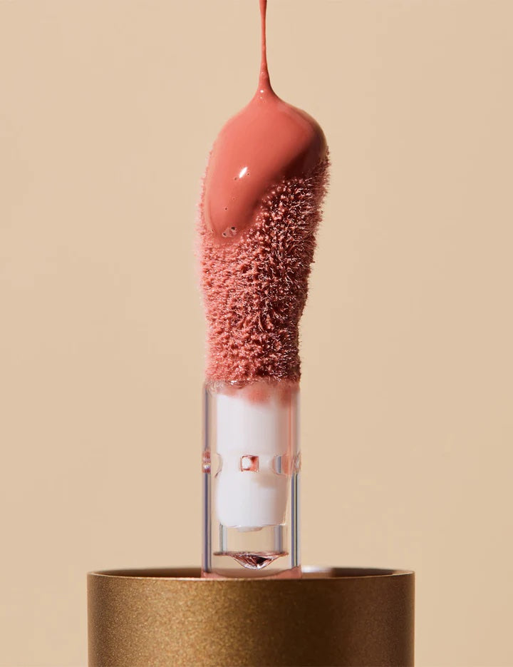 Lip balm with a textured pink top on a beige background