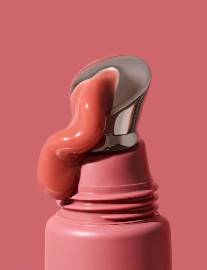 Pink lip balm with a silver cap on a pink background