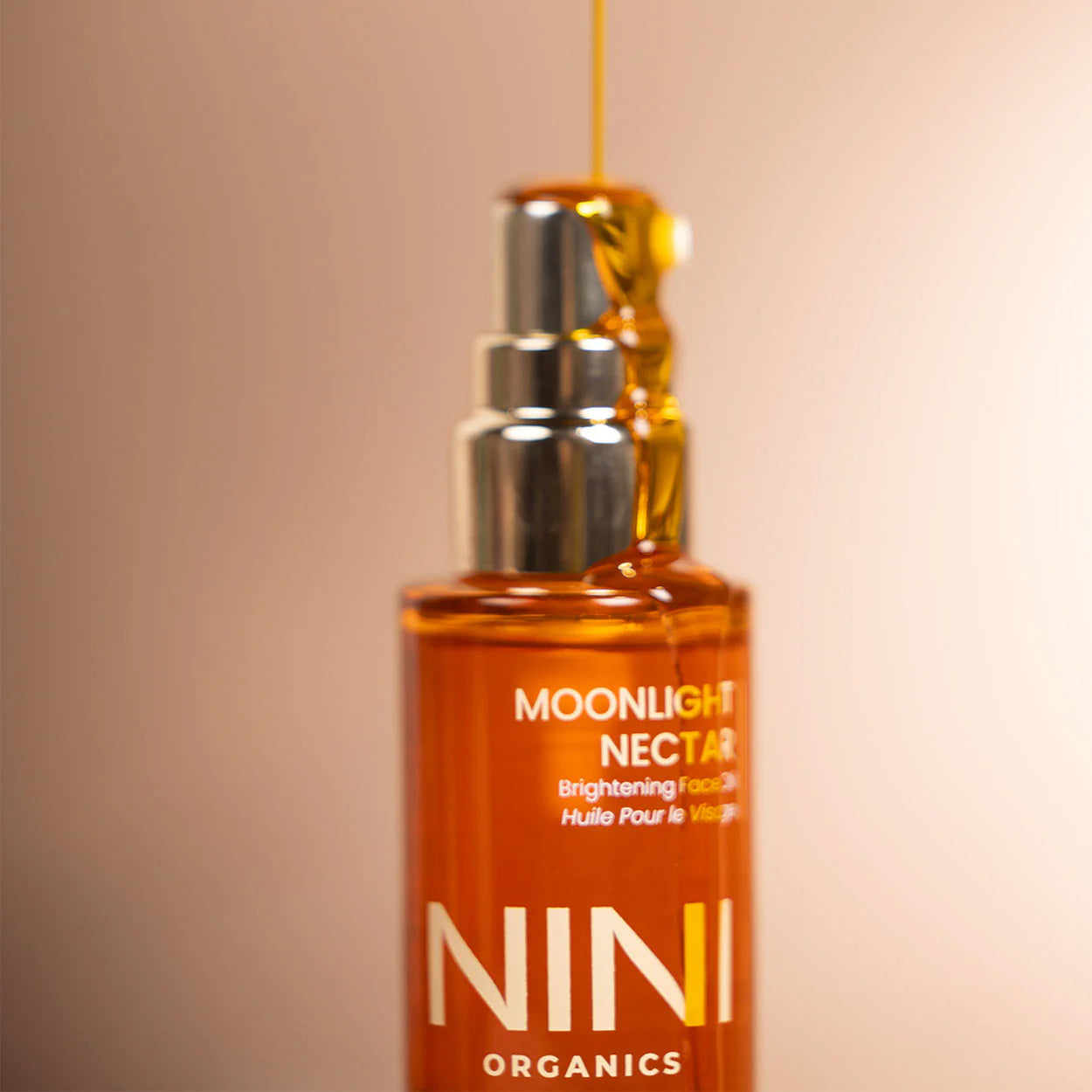 NINI Moonlight Nectar by NINI Organics on a beige background dispensing