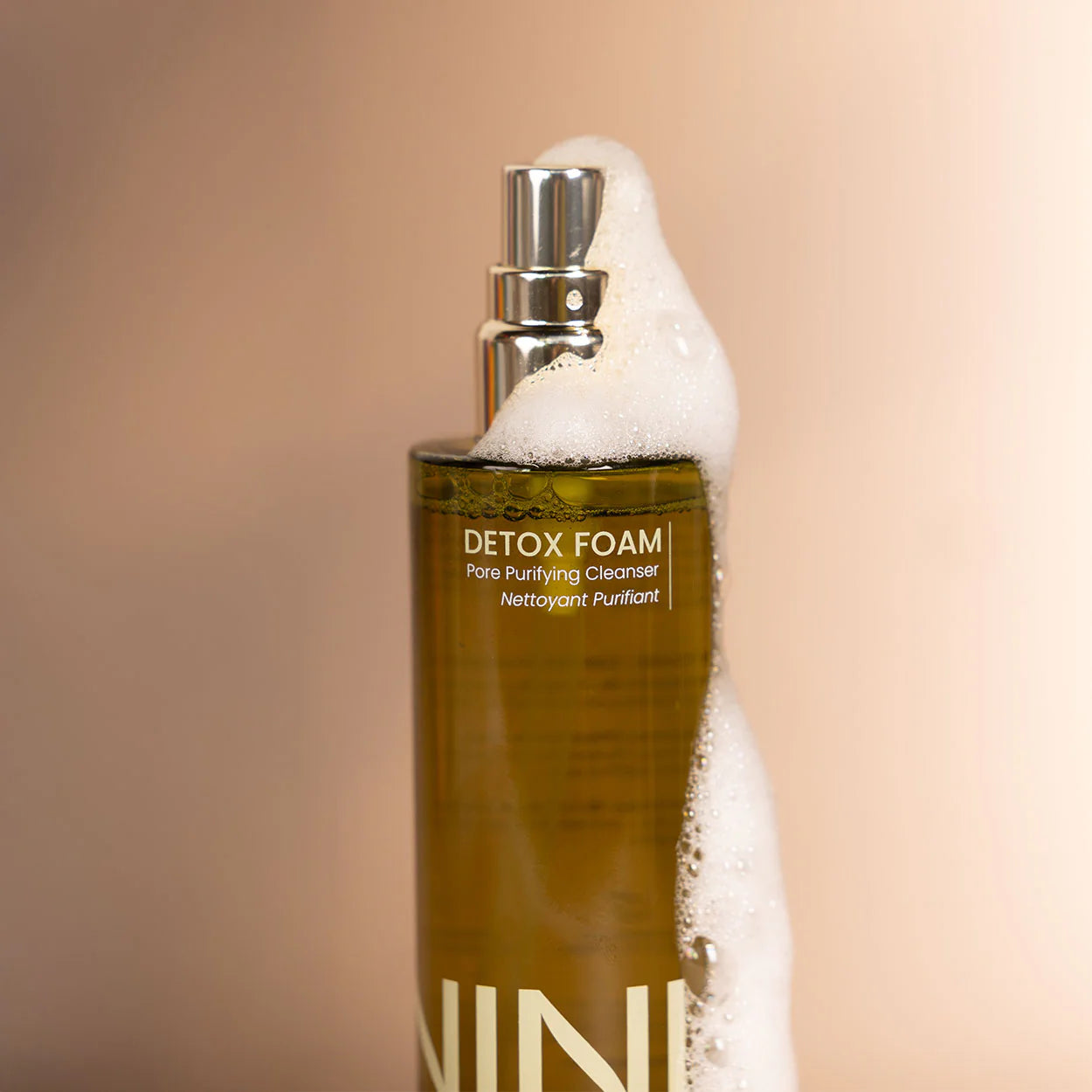 Bottle of Detox Foam with a foamy head on a beige background