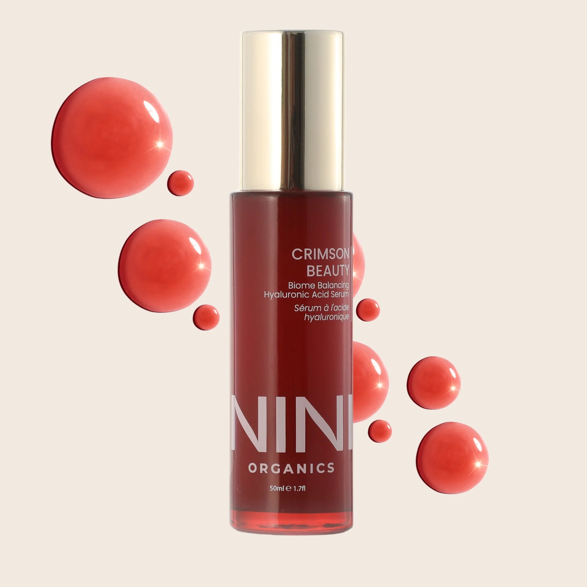 Red NINI Organic skincare serum bottle with gold cap on a beige background