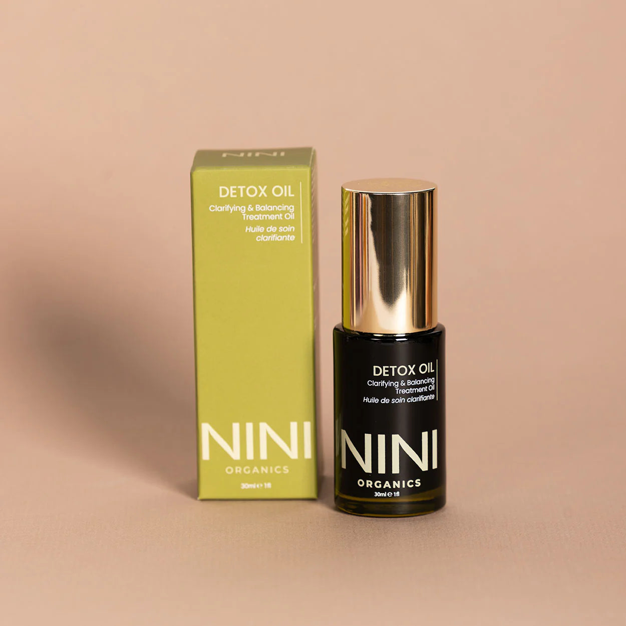 NINI Organics detox oil bottle and packaging on a beige background