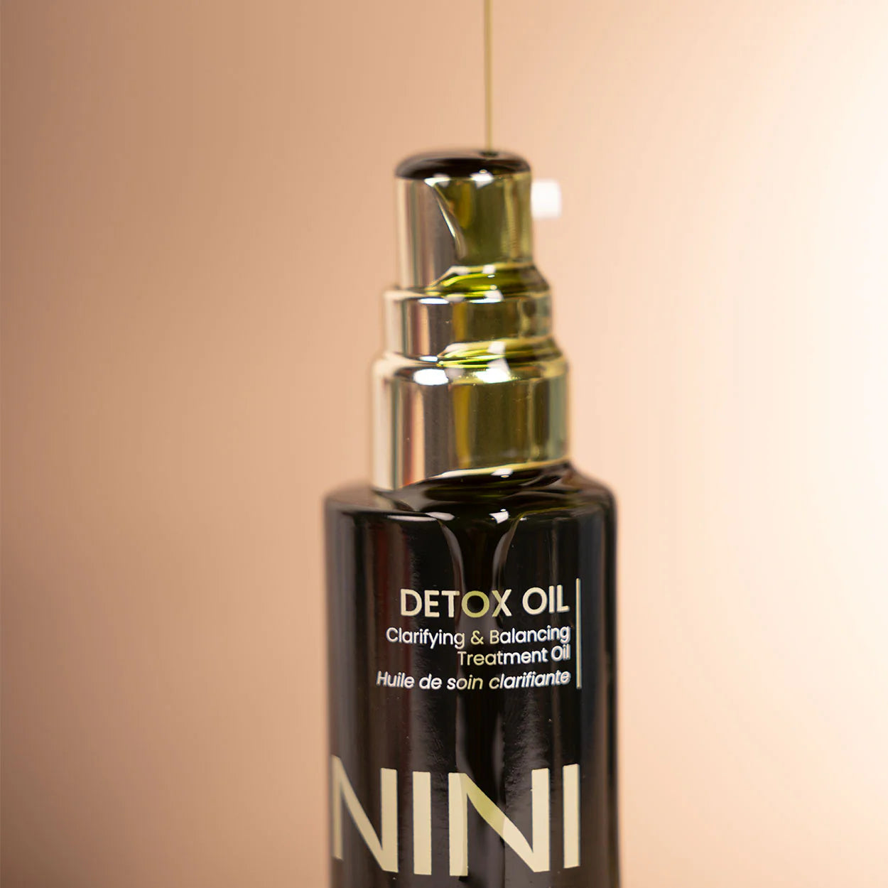 NINI Organics Detox oil bottle with dropper on a beige background dispensed