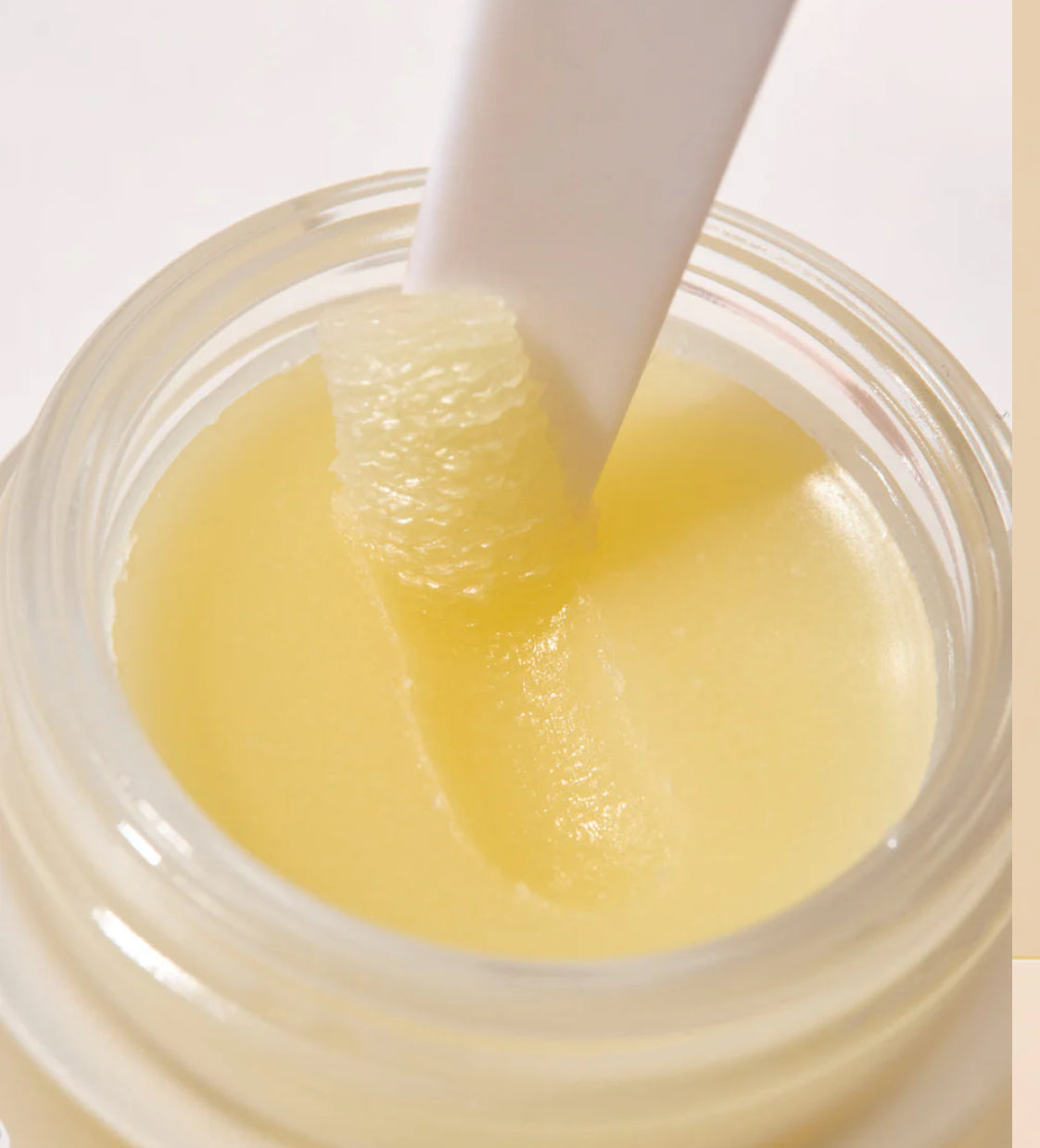 Jar of yellow cream with a white spatula