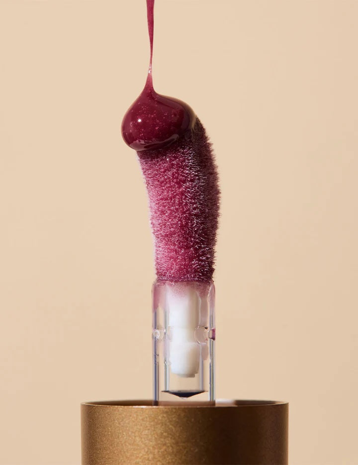 Pink textured object with a droplet on a beige background