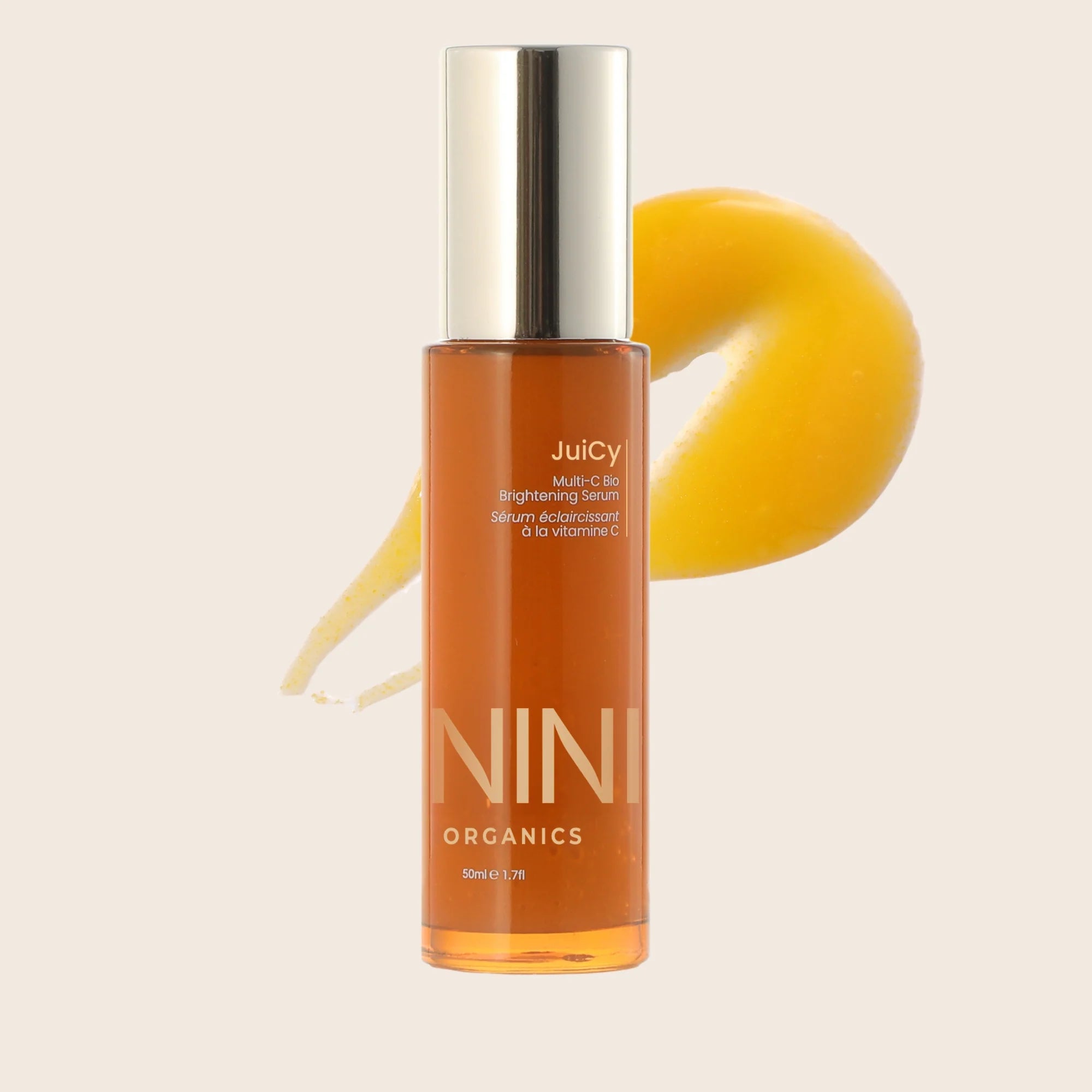 Juicy Nini Organics skincare serum bottle with a yellow background