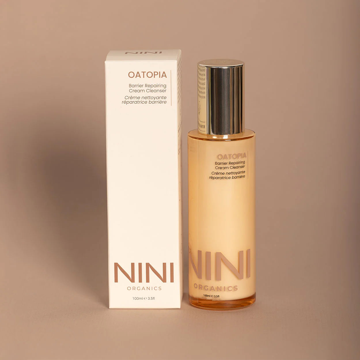 NINI Organics skincare bottle and box on a beige background