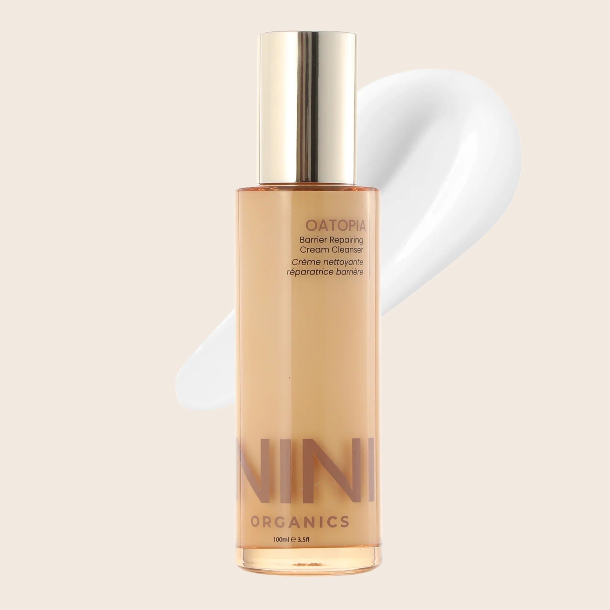 Oatopia cream cleaner Skincare bottle with gold cap and label on a beige background from NINI Organics