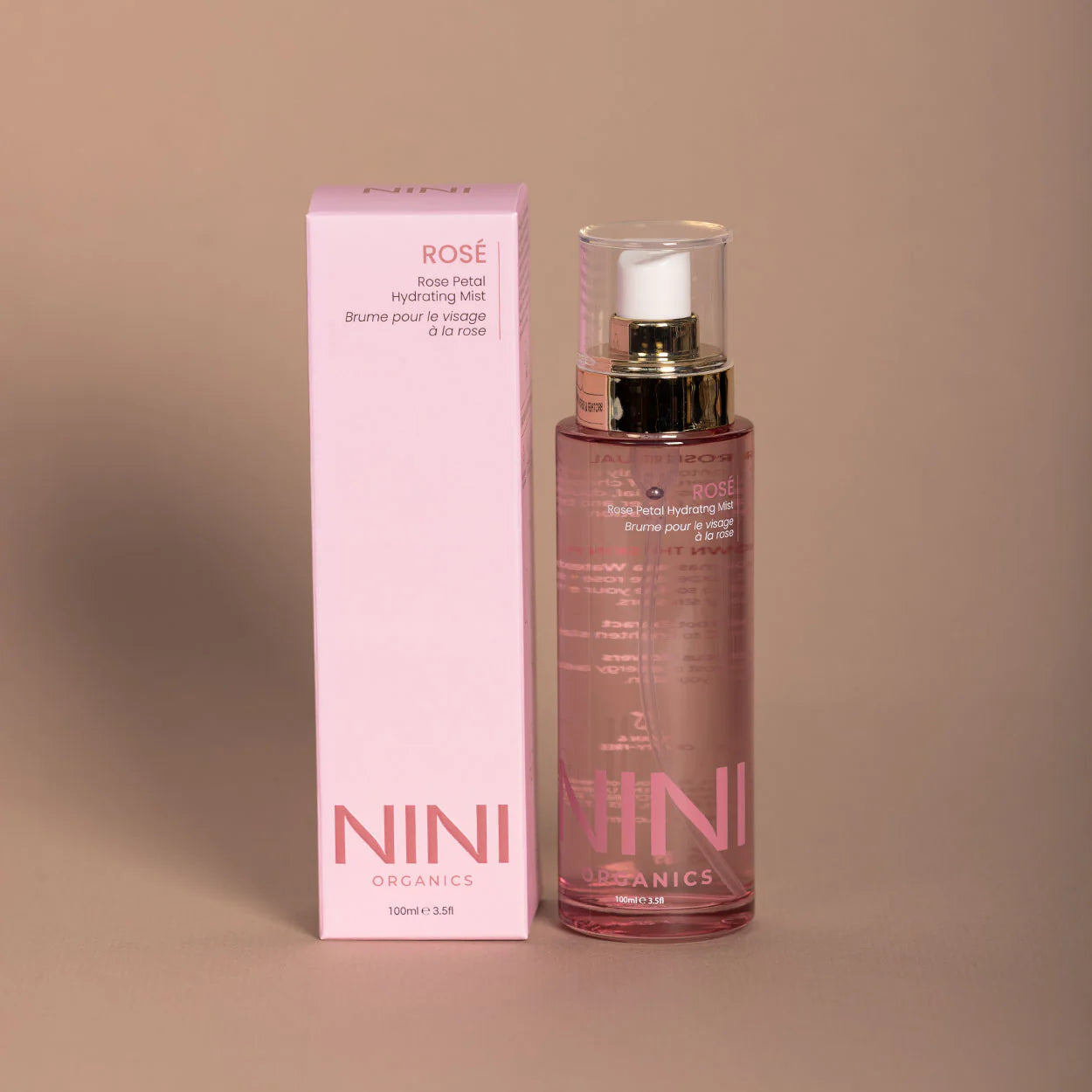 NINI Organics rose facial mist and packaging on a beige background