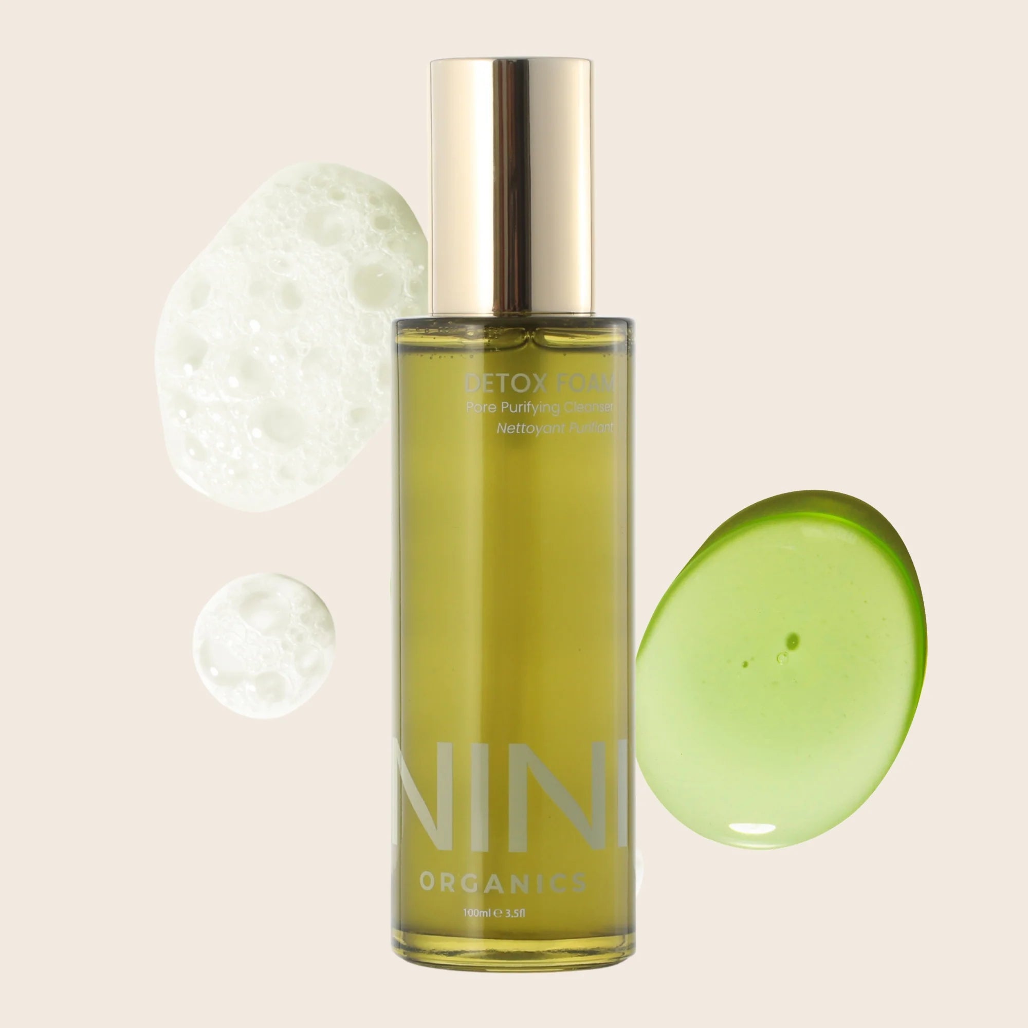 NINI Organic Green skincare product bottle with gold cap on a beige background