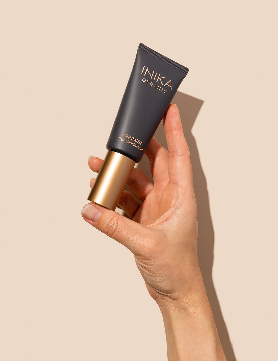 INIKA Certified Organic Pure Perfection Primer 30ml being held by a hand